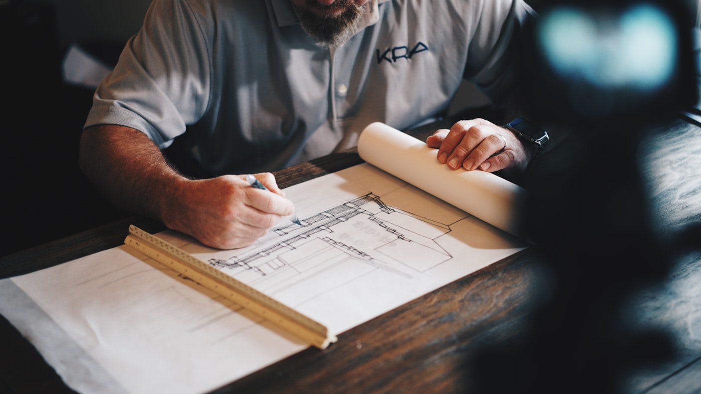 Ingeniero revisando planos técnicos sobre la mesa de trabajo